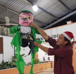 En una posada de Morena, su presidente Mario Mex golpea una piñata parecida a “Huacho” Díaz